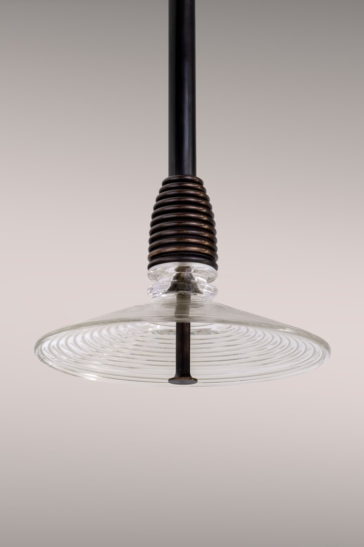 Pendant lamp in dark brass and clear glass.