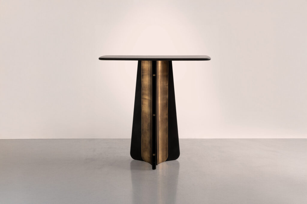 The Propeller console in metal and wood, shown is the single pedestal base option in blackened steel, light-etched brass and bullnosed dark oak.
