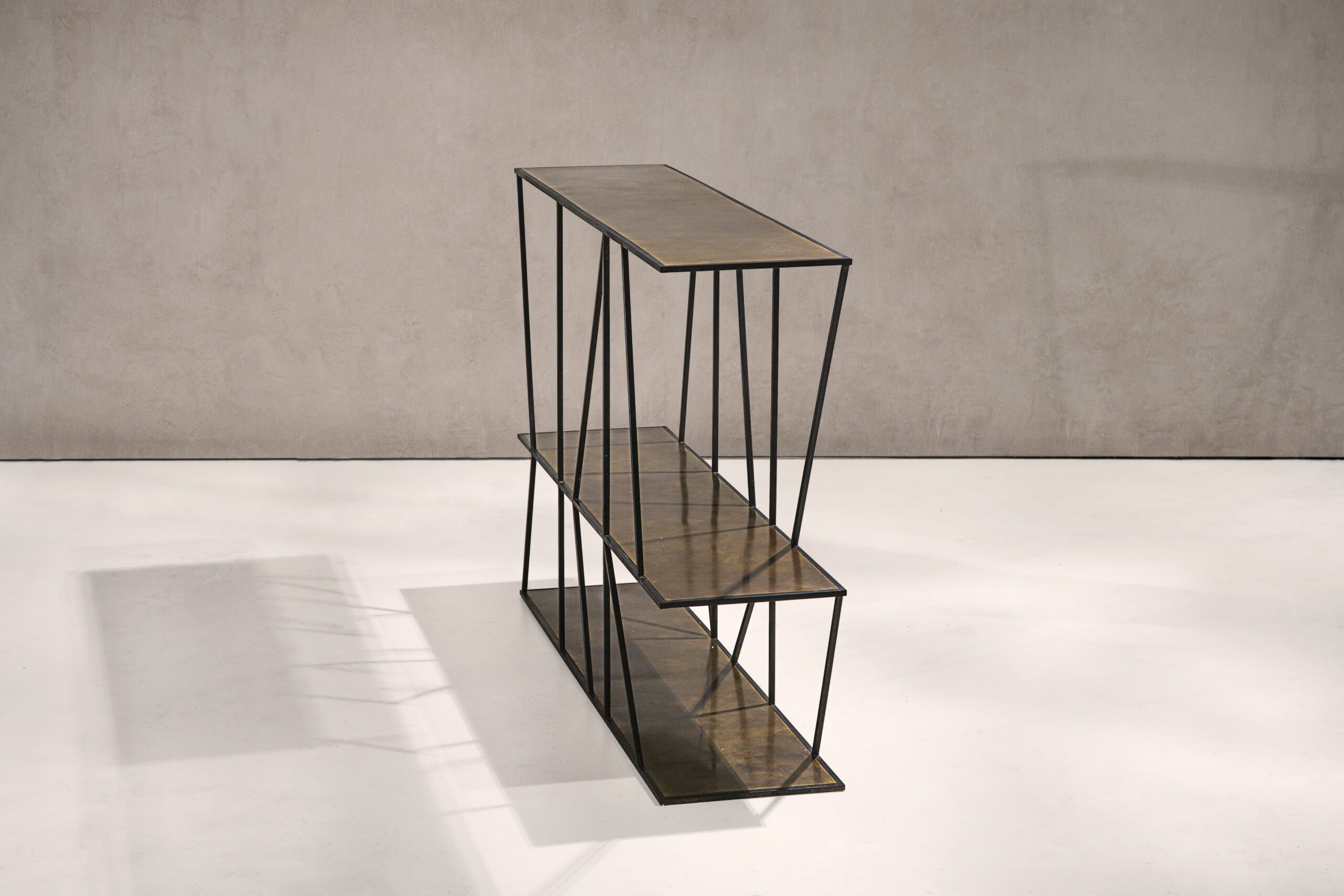 A sculptural console table in black patinated steel and patinated brass.