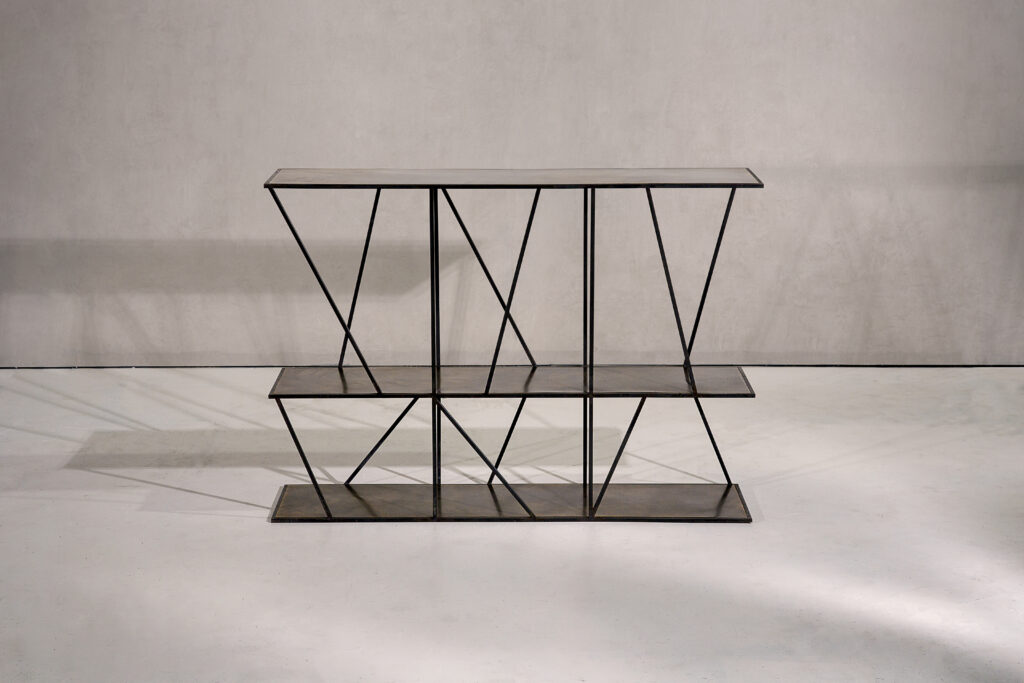 A sculptural console table in black patinated steel and patinated brass.